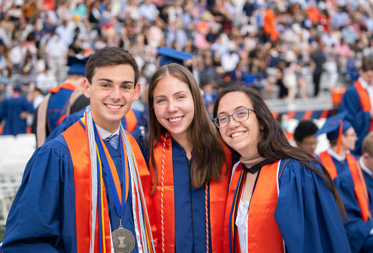 three students in commencement regalia