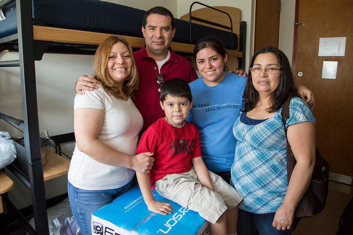HIspani c family with student moving into dorm room